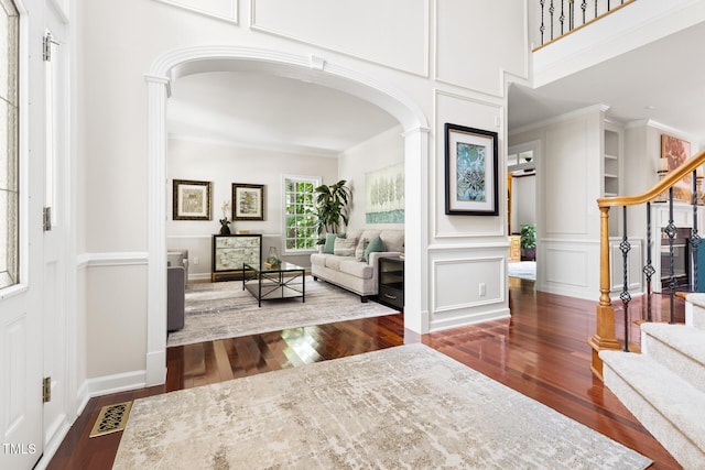 5106 Stockton Way, Durham, NC 27707 - entryway with arched walkways, wood finished floors, stairs, ornamental molding, and a decorative wall