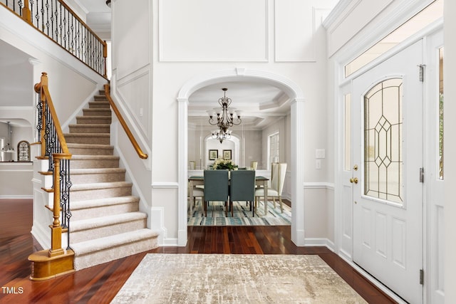 5106 Stockton Way, Durham, NC 27707 - foyer entrance featuring a chandelier, dark wood-style flooring, ornamental molding, arched walkways, and stairs