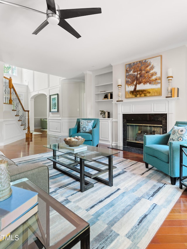 5106 Stockton Way, Durham, NC 27707 - living area featuring arched walkways, stairs, wood finished floors, ceiling fan, and a fireplace