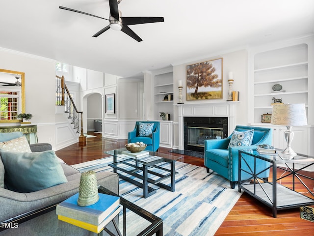 5106 Stockton Way, Durham, NC 27707 - living area featuring arched walkways, a ceiling fan, stairway, wood finished floors, and a fireplace