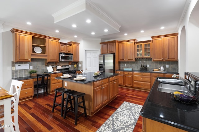 5106 Stockton Way, Durham, NC 27707 - kitchen with stainless steel appliances, brown cabinetry, arched walkways, ornamental molding, and dark wood-style floors