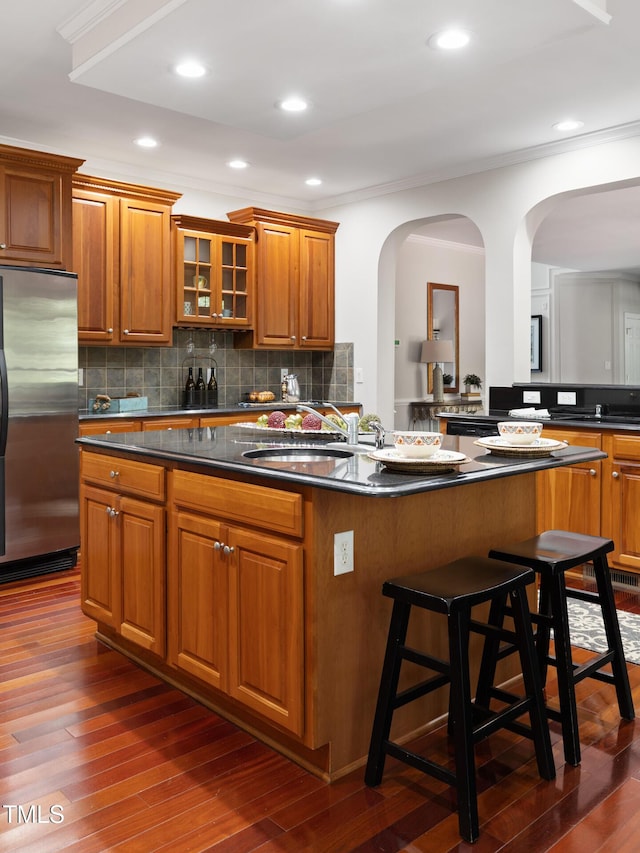 5106 Stockton Way, Durham, NC 27707 - kitchen with stainless steel refrigerator, a center island, brown cabinetry, dark countertops, and ornamental molding