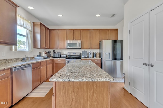 2123 Scarlet Sage Dr, Durham, NC 27704 - kitchen featuring stainless steel appliances, a kitchen island, light stone countertops, light wood-style floors, and recessed lighting