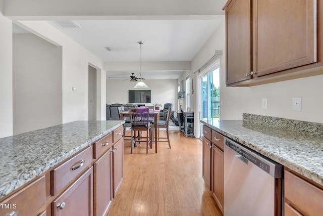 2123 Scarlet Sage Dr, Durham, NC 27704 - kitchen with stainless steel dishwasher, light wood finished floors, light stone countertops, open floor plan, and hanging light fixtures
