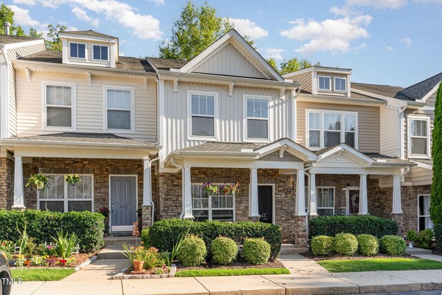 8823 Orchard Grove Way, Raleigh, NC 27612 - view of property with a porch, board and batten siding, stone siding, and a shingled roof