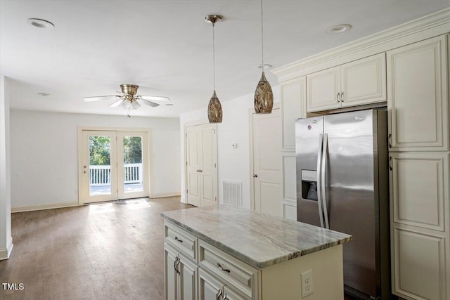 1309 Hill St, Durham, NC 27707 - kitchen featuring stainless steel fridge with ice dispenser, cream cabinets, ceiling fan, light stone countertops, and wood finished floors