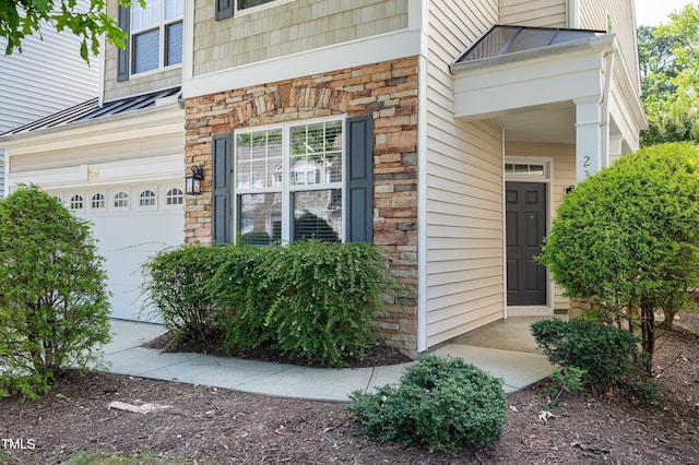 238 Royal Tower Way, Cary, NC 27513 - view of exterior entry with stone siding, an attached garage, and a standing seam roof
