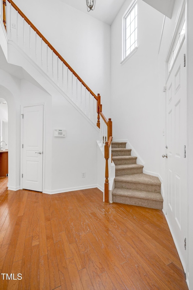 238 Royal Tower Way, Cary, NC 27513 - foyer featuring light wood-type flooring, stairs, arched walkways, and a high ceiling