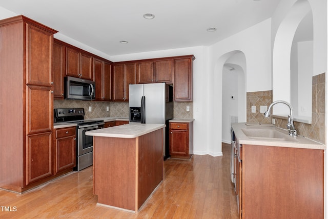 238 Royal Tower Way, Cary, NC 27513 - kitchen featuring stainless steel appliances, arched walkways, tasteful backsplash, light wood-type flooring, and light countertops