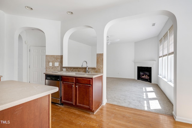 238 Royal Tower Way, Cary, NC 27513 - kitchen with dishwasher, light wood finished floors, light countertops, a fireplace, and a ceiling fan