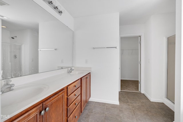 238 Royal Tower Way, Cary, NC 27513 - bathroom featuring a shower stall, double vanity, a walk in closet, and tile patterned floors