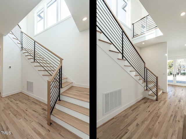 1009 Parker St, Raleigh, NC 27607 - staircase featuring wood finished floors, french doors, recessed lighting, a high ceiling, and a skylight