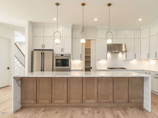 1009 Parker St, Raleigh, NC 27607 - kitchen with stainless steel appliances, wall chimney range hood, a large island, backsplash, and light wood-style floors