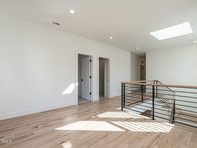1009 Parker St, Raleigh, NC 27607 - empty room featuring a skylight, light wood-style flooring, and recessed lighting