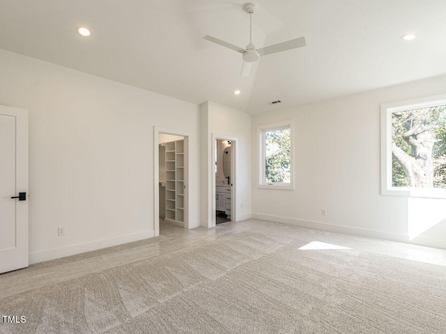 1009 Parker St, Raleigh, NC 27607 - unfurnished bedroom featuring light carpet, multiple windows, a walk in closet, recessed lighting, and a closet