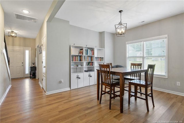 606 N Dickson St, Raeford, NC 28376 - dining area with light wood-type flooring and a chandelier