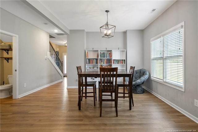 606 N Dickson St, Raeford, NC 28376 - dining room with a chandelier, wood finished floors, stairway, and recessed lighting