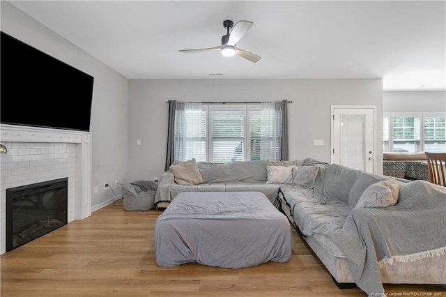 606 N Dickson St, Raeford, NC 28376 - living room featuring ceiling fan, a fireplace, and light wood-type flooring