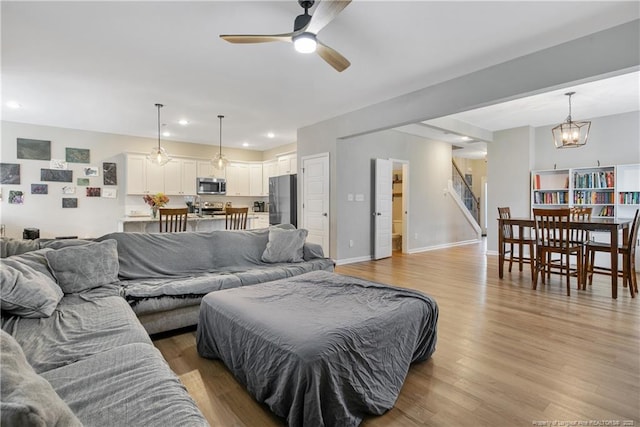 606 N Dickson St, Raeford, NC 28376 - living room with stairs, a ceiling fan, light wood-type flooring, recessed lighting, and a chandelier