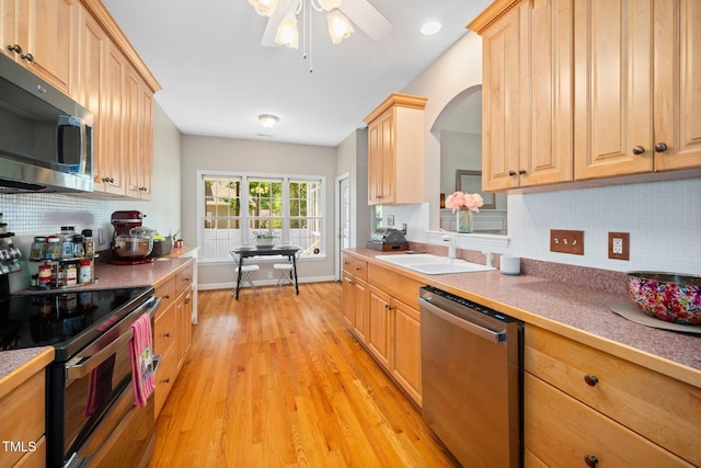904 E Ivy Valley Dr, Fuquay Varina, NC 27526 - kitchen with stainless steel appliances, light wood-style floors, tasteful backsplash, and light brown cabinetry