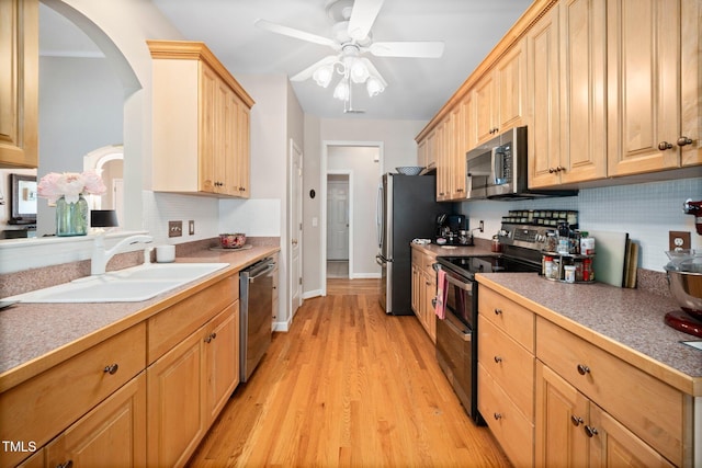 904 E Ivy Valley Dr, Fuquay Varina, NC 27526 - kitchen featuring stainless steel appliances, tasteful backsplash, light brown cabinetry, light wood-type flooring, and arched walkways