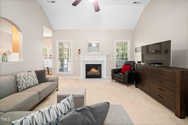 904 E Ivy Valley Dr, Fuquay Varina, NC 27526 - living room with lofted ceiling, a ceiling fan, light colored carpet, a premium fireplace, and arched walkways