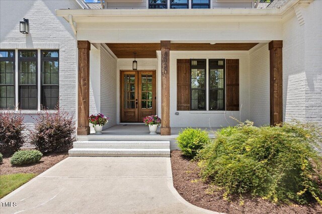 8420 Bells Lake Rd, Apex, NC 27539 - view of exterior entry with brick siding, a porch, and french doors