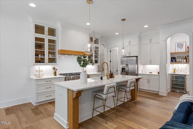 8420 Bells Lake Rd, Apex, NC 27539 - kitchen featuring wine cooler, stainless steel refrigerator with ice dispenser, light wood-style floors, a breakfast bar, and white cabinets