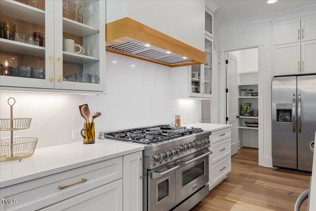 8420 Bells Lake Rd, Apex, NC 27539 - kitchen with stainless steel appliances, custom exhaust hood, light countertops, light wood finished floors, and white cabinets