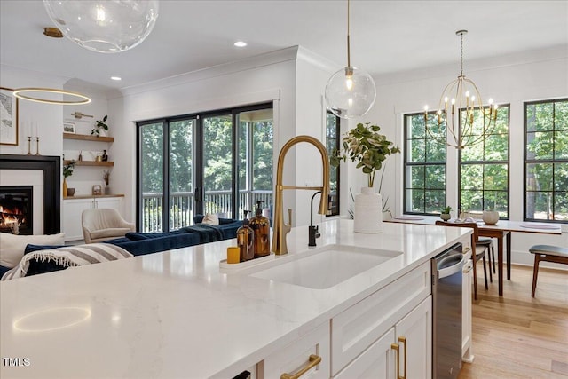 8420 Bells Lake Rd, Apex, NC 27539 - kitchen featuring open floor plan, a chandelier, ornamental molding, light stone counters, and light wood-style flooring