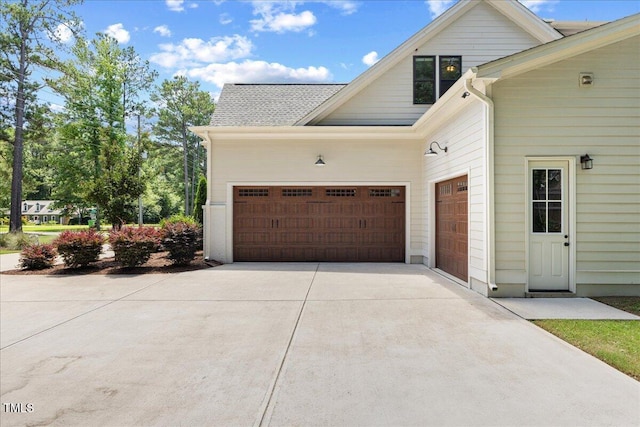 8420 Bells Lake Rd, Apex, NC 27539 - view of side of property featuring driveway, an attached garage, and roof with shingles