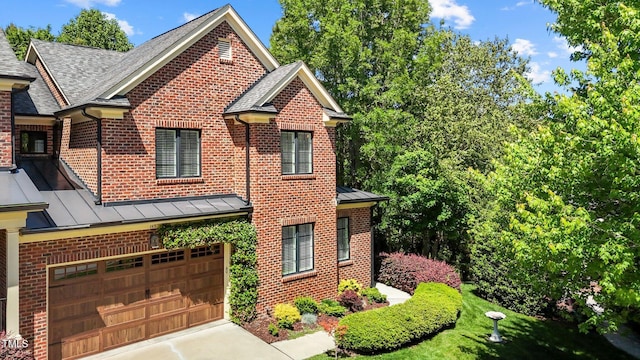 145 Cofield Cir, Durham, NC 27707 - view of front of house with a standing seam roof, a garage, and brick siding