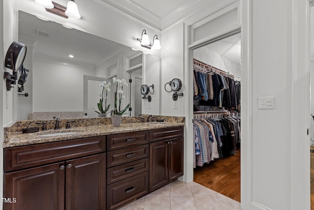 145 Cofield Cir, Durham, NC 27707 - bathroom with crown molding, double vanity, a walk in closet, and tile patterned floors
