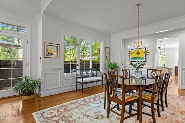 145 Cofield Cir, Durham, NC 27707 - dining room with a decorative wall, crown molding, a chandelier, light wood-type flooring, and wainscoting