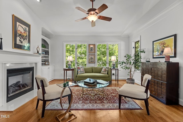 145 Cofield Cir, Durham, NC 27707 - living area featuring ceiling fan, a glass covered fireplace, built in features, and light wood-style floors