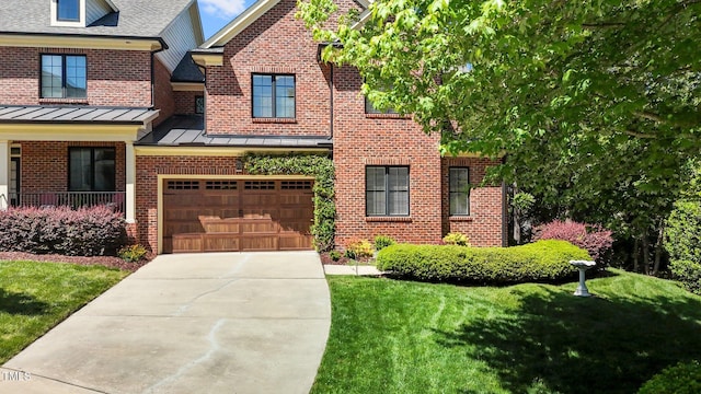145 Cofield Cir, Durham, NC 27707 - view of front of house with brick siding, concrete driveway, a standing seam roof, a garage, and a front yard