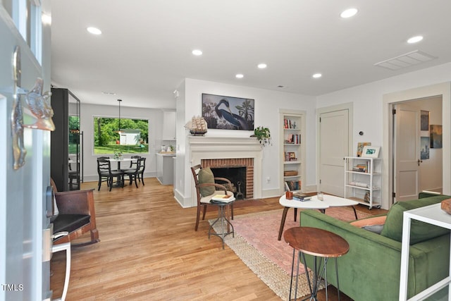 2410 Huron St, Durham, NC 27707 - living area with light wood finished floors, built in features, recessed lighting, and a brick fireplace