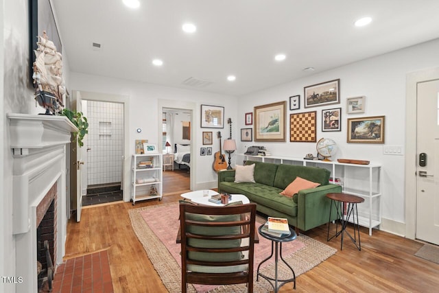 2410 Huron St, Durham, NC 27707 - living area featuring a brick fireplace, wood finished floors, and recessed lighting