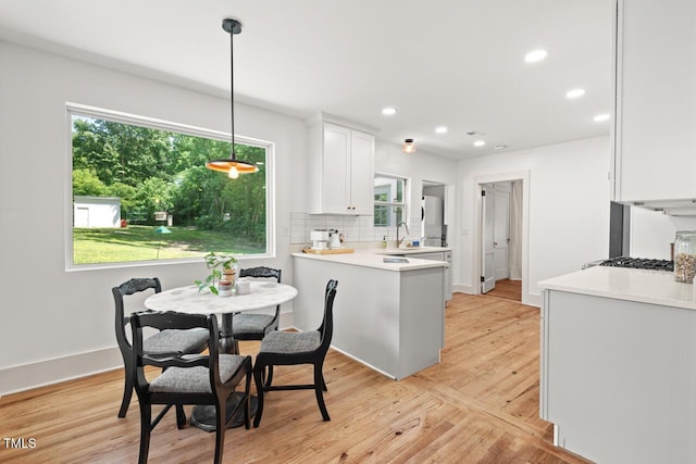 2410 Huron St, Durham, NC 27707 - kitchen with white cabinetry, light countertops, recessed lighting, light wood finished floors, and decorative backsplash