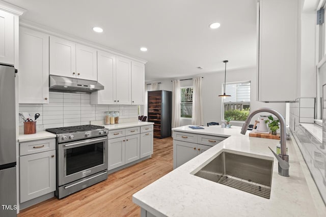 2410 Huron St, Durham, NC 27707 - kitchen with stainless steel appliances, under cabinet range hood, backsplash, recessed lighting, and light stone counters