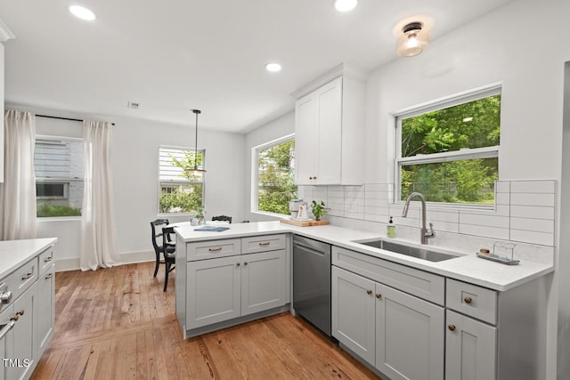 2410 Huron St, Durham, NC 27707 - kitchen with stainless steel dishwasher, a peninsula, light countertops, tasteful backsplash, and recessed lighting