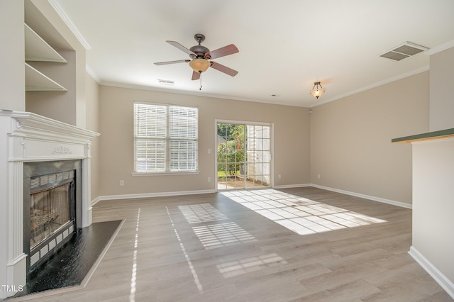 2261 Plum Frost Dr, Raleigh, NC 27603 - unfurnished living room featuring a fireplace with raised hearth, crown molding, light wood-style flooring, and a ceiling fan