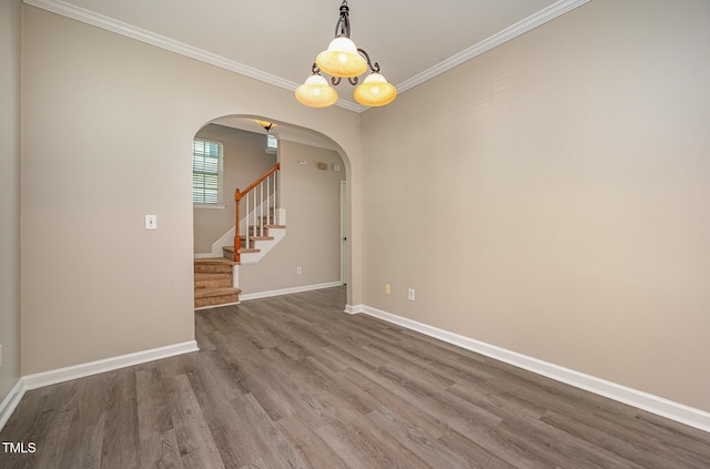 2261 Plum Frost Dr, Raleigh, NC 27603 - unfurnished room featuring arched walkways, dark wood-type flooring, crown molding, and stairway