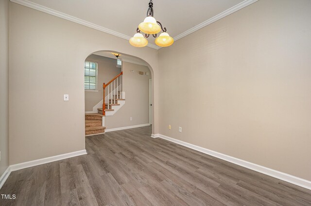 2261 Plum Frost Dr, Raleigh, NC 27603 - unfurnished room featuring arched walkways, dark wood-type flooring, crown molding, and stairway