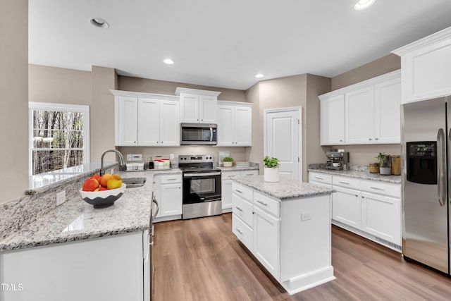 3041 Wesley Farm Ln, Sophia, NC 27350 - kitchen featuring stainless steel appliances, a peninsula, light wood-style floors, white cabinets, and recessed lighting