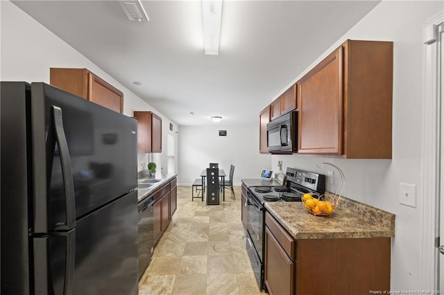 534 Jernigan St, Fayetteville, NC 28306 - kitchen featuring black appliances, stone finish flooring, and brown cabinets
