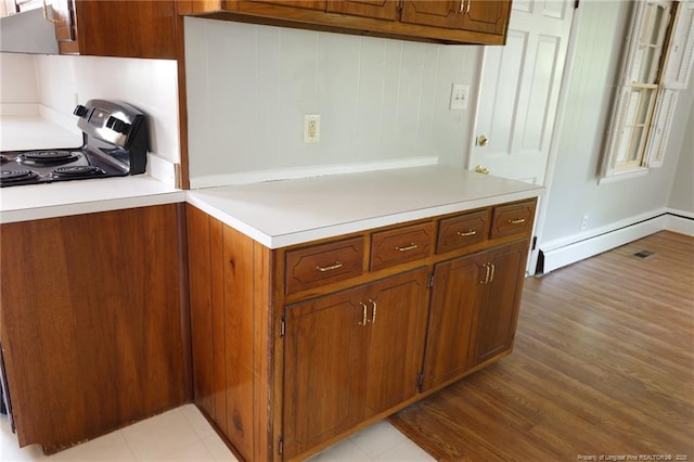 103 Stedman St, Fayetteville, NC 28305 - kitchen with baseboard heating, light countertops, light wood-style flooring, and brown cabinetry