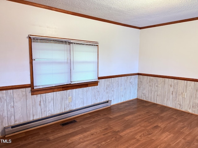 1222 Perkins Rd, Robersonville, NC 27871 - unfurnished room with a wainscoted wall, baseboard heating, wood finished floors, crown molding, and wood walls