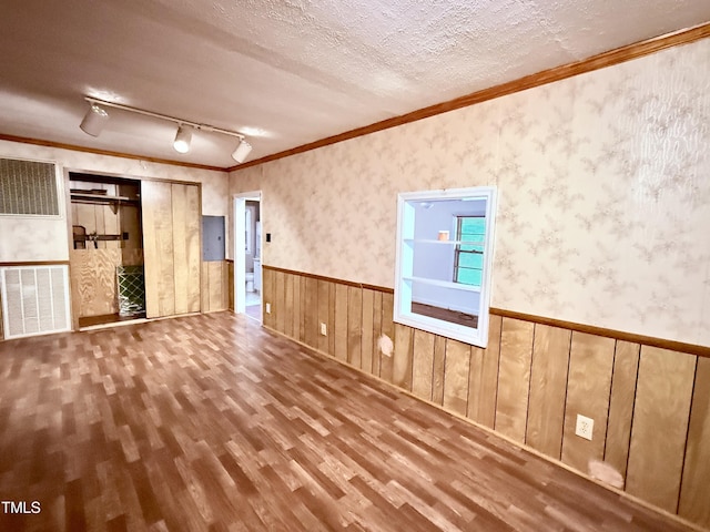 1222 Perkins Rd, Robersonville, NC 27871 - unfurnished living room with a wainscoted wall, wood finished floors, ornamental molding, rail lighting, and a textured ceiling