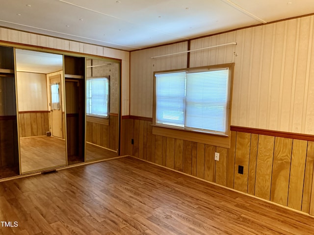 1222 Perkins Rd, Robersonville, NC 27871 - unfurnished bedroom featuring wood finished floors, wood walls, and a closet